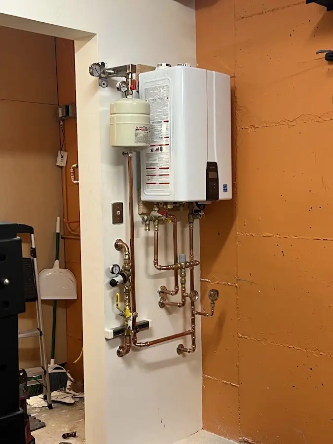Plumbing technician inspecting water heater connections in North Mankato